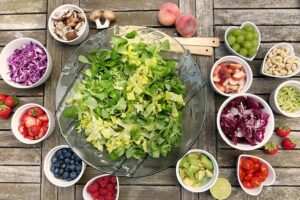 Plato de ensalada verde con frutas, verduras y frutos secos, alimentos naturales que ayudan a prevenir infecciones de orina